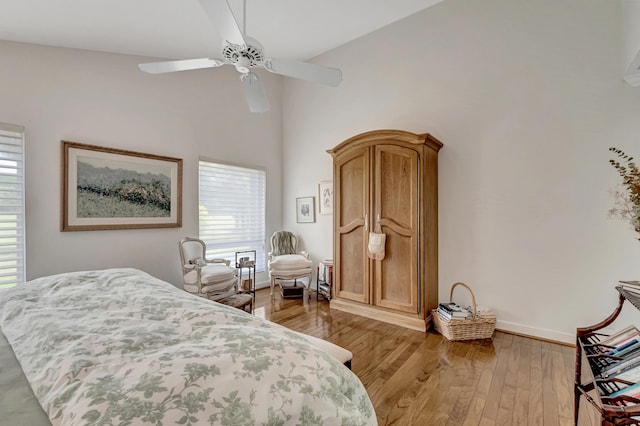 bedroom featuring high vaulted ceiling, multiple windows, ceiling fan, and light hardwood / wood-style floors