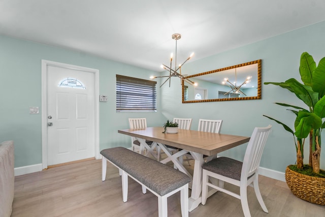 9531 Birdwood St, Palm Beach Gardens, FL 33410 - dining area featuring a chandelier, light wood-style floors, and baseboards
