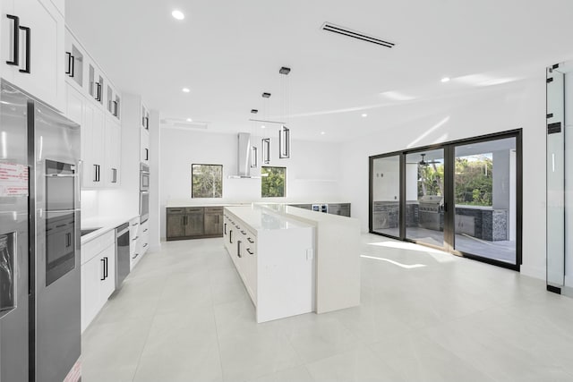 kitchen with a spacious island, plenty of natural light, decorative light fixtures, and white cabinets