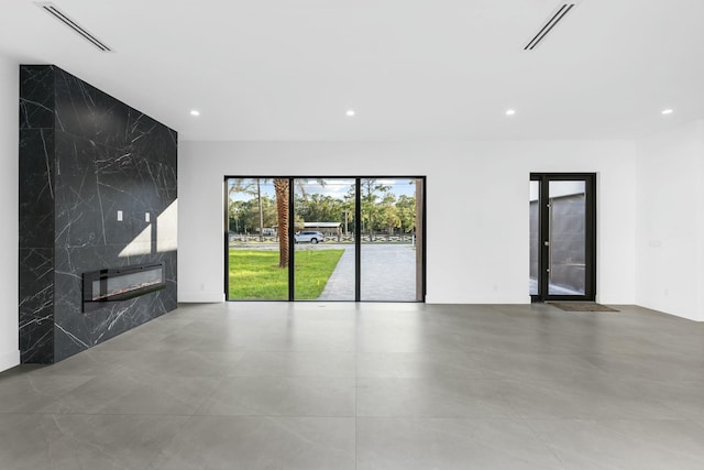 unfurnished living room featuring a premium fireplace and tile walls