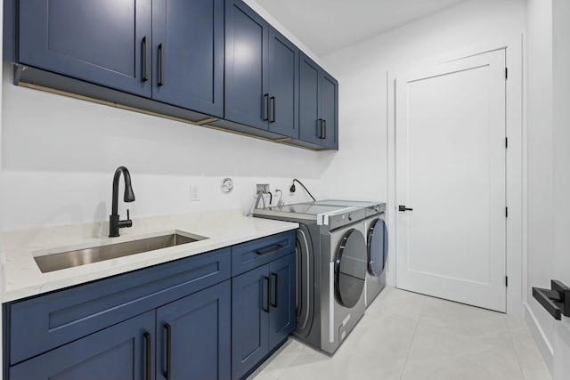 clothes washing area featuring cabinets, sink, washer and dryer, and light tile patterned floors