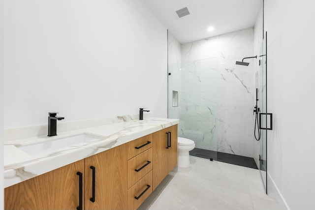 bathroom with vanity, a shower with door, and toilet