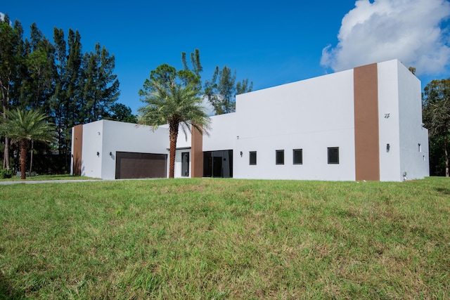 view of front of house featuring a garage and a front lawn