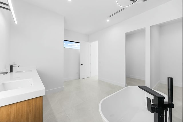 bathroom featuring vanity, tile patterned flooring, and a tub