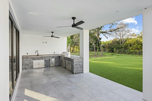 view of patio with ceiling fan, an outdoor kitchen, sink, and grilling area