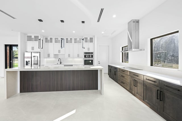 kitchen with stainless steel appliances, decorative light fixtures, range hood, and white cabinets