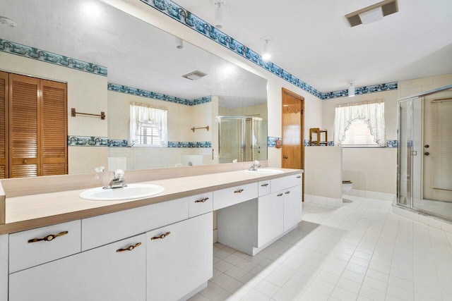 bathroom featuring vanity, an enclosed shower, tile patterned flooring, and tile walls