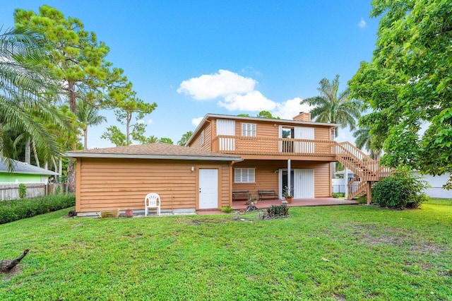 rear view of house featuring a yard, a deck, and a patio