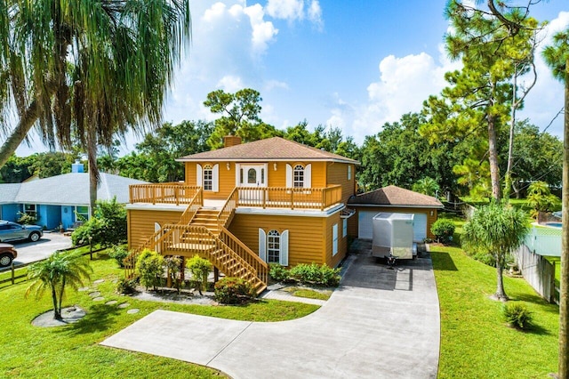 mediterranean / spanish house with a garage, an outbuilding, a front yard, and a wooden deck