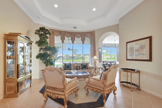 tiled living room with crown molding and a tray ceiling