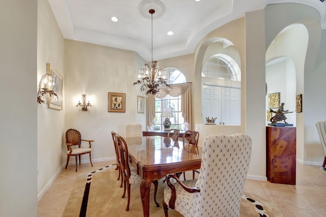 tiled dining space with a notable chandelier and a tray ceiling