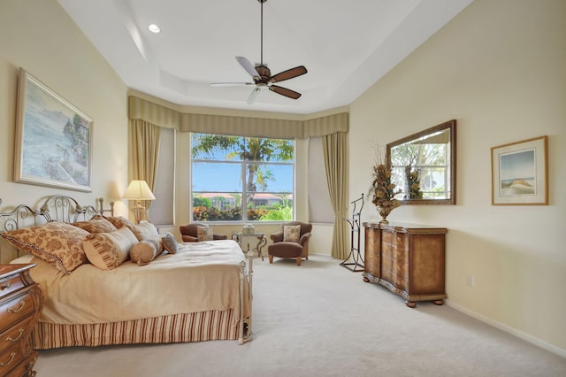 bedroom featuring carpet, ceiling fan, and a tray ceiling