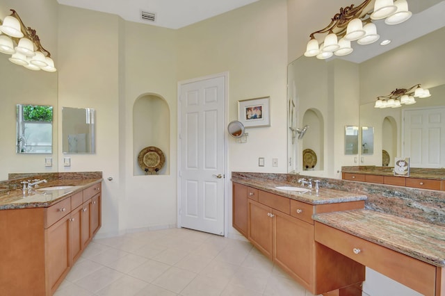 bathroom with tile patterned flooring, a towering ceiling, and double vanity