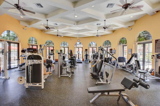 gym featuring coffered ceiling, french doors, and ceiling fan