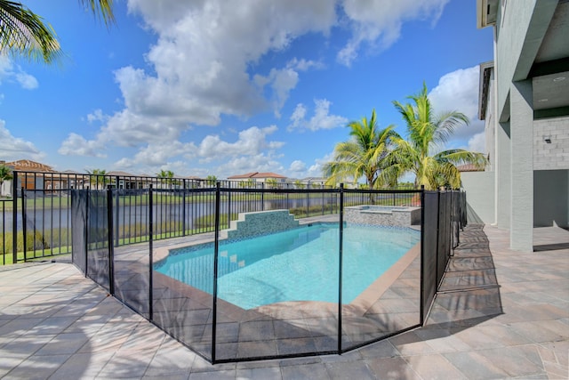 view of pool with an in ground hot tub, a water view, and a patio area