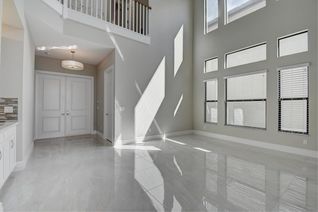 unfurnished living room with a high ceiling