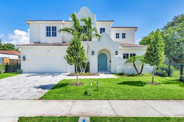 mediterranean / spanish home featuring a garage and a front lawn