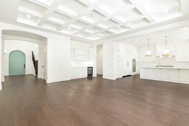 unfurnished living room with beamed ceiling, dark hardwood / wood-style floors, wine cooler, and coffered ceiling