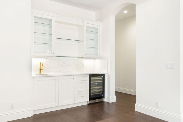 bar with white cabinets, dark hardwood / wood-style flooring, sink, and wine cooler