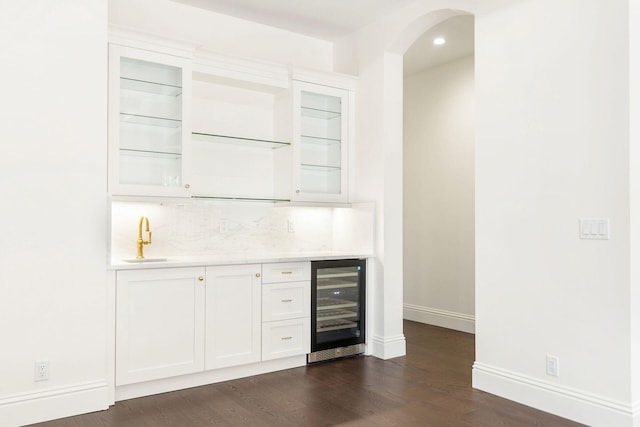 bar featuring sink, backsplash, wine cooler, white cabinets, and dark hardwood / wood-style flooring