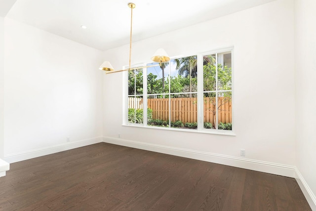 unfurnished dining area with dark wood-type flooring and a chandelier