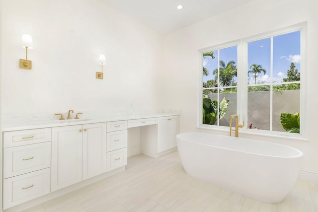 bathroom with a tub, vanity, and tile patterned flooring