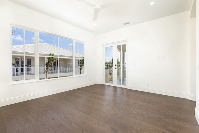 empty room featuring ceiling fan, dark hardwood / wood-style flooring, and french doors