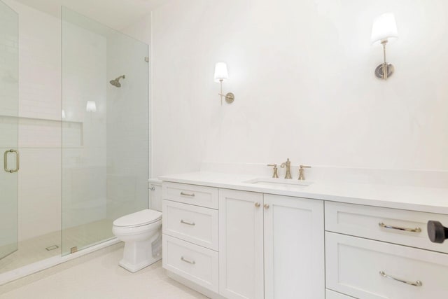 bathroom featuring tile patterned floors, vanity, toilet, and a shower with shower door