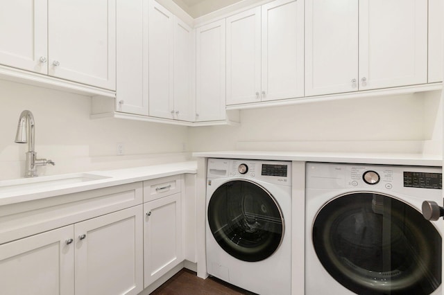 laundry room with separate washer and dryer, sink, and cabinets