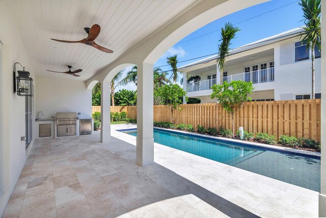 view of swimming pool with a patio, area for grilling, an outdoor kitchen, and ceiling fan