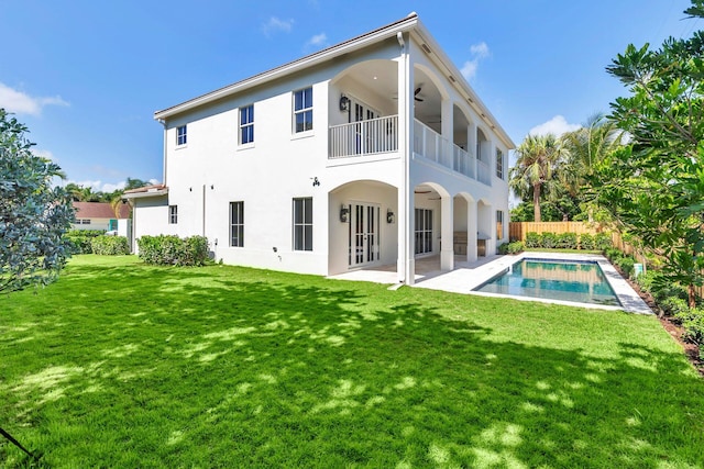 back of house with a lawn, ceiling fan, a patio, french doors, and a balcony