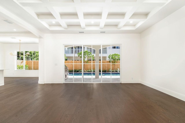 empty room with dark hardwood / wood-style flooring, coffered ceiling, and beamed ceiling