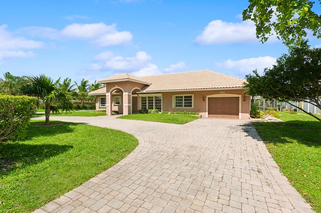 mediterranean / spanish-style house featuring a garage and a front yard