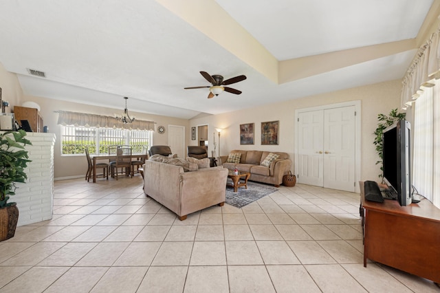 living room with light tile patterned flooring and ceiling fan with notable chandelier