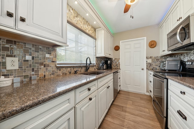 kitchen with ceiling fan, white cabinets, tasteful backsplash, and stainless steel appliances