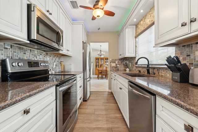 kitchen featuring sink, decorative backsplash, appliances with stainless steel finishes, and white cabinetry