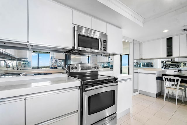 kitchen with appliances with stainless steel finishes, white cabinets, sink, crown molding, and light tile patterned flooring