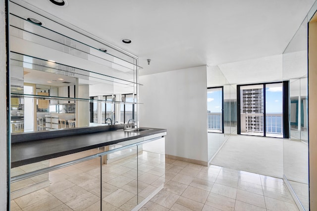 interior space featuring sink, a wealth of natural light, and light tile patterned floors