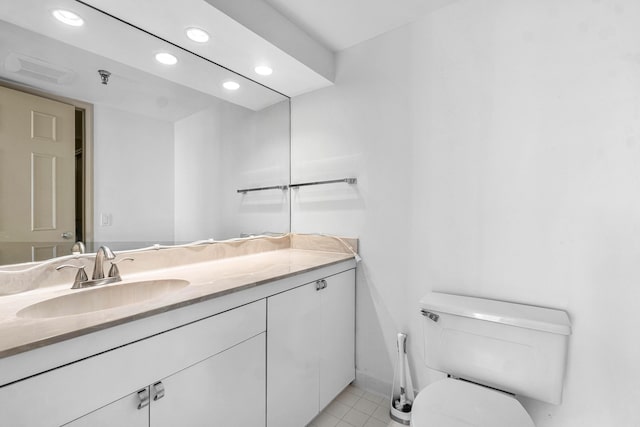 bathroom featuring tile patterned flooring, toilet, and vanity