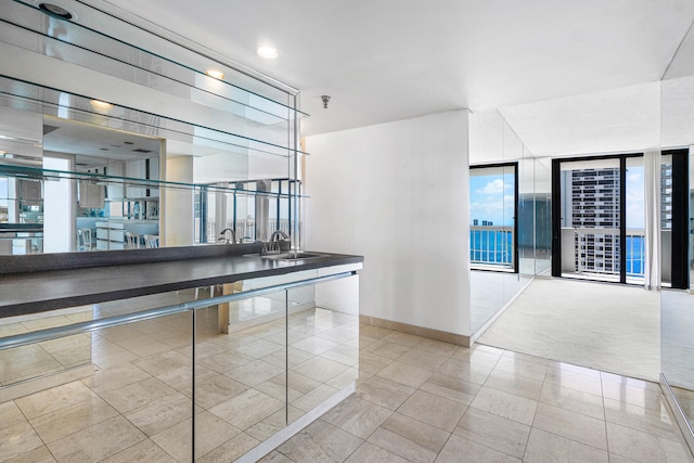 hallway with sink, light tile patterned floors, and floor to ceiling windows