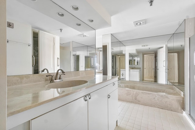 bathroom with tile patterned flooring, a bath, and vanity