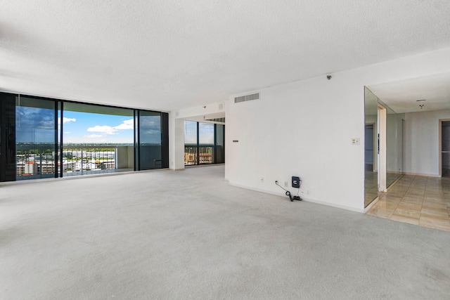 unfurnished living room featuring a textured ceiling and light colored carpet