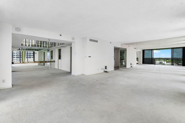 unfurnished living room with carpet and a textured ceiling