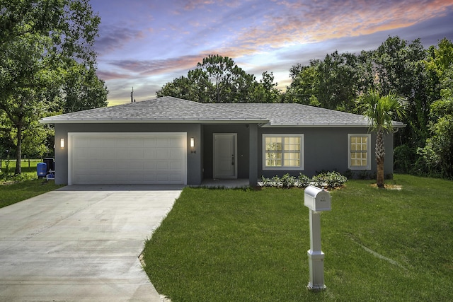 view of front of home featuring a garage and a lawn