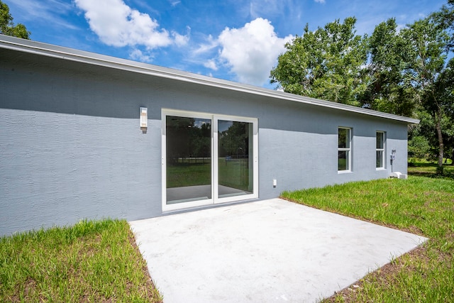 rear view of property with a lawn and a patio area