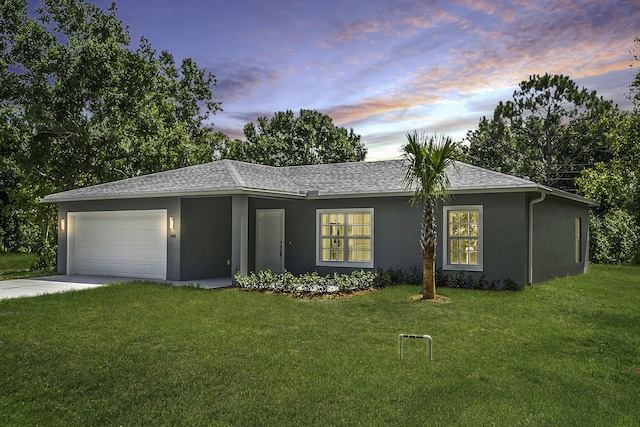 view of front of house featuring a garage and a lawn