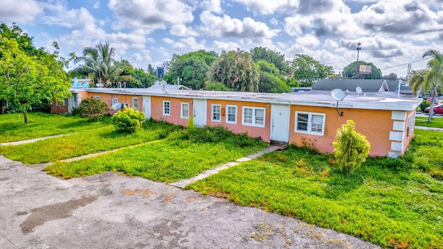 single story home featuring a front lawn