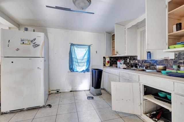 kitchen featuring tasteful backsplash, white cabinetry, open shelves, and freestanding refrigerator