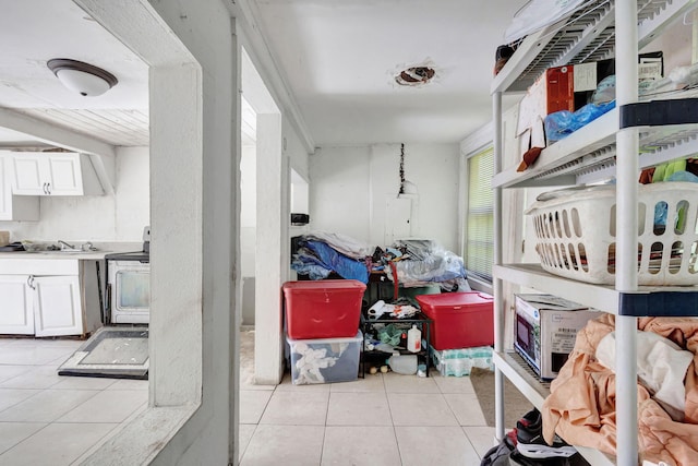 interior space with light tile patterned floors, washer / clothes dryer, and white cabinets