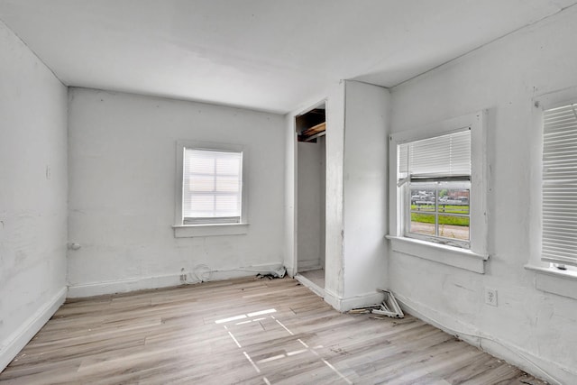 unfurnished bedroom featuring multiple windows and wood finished floors